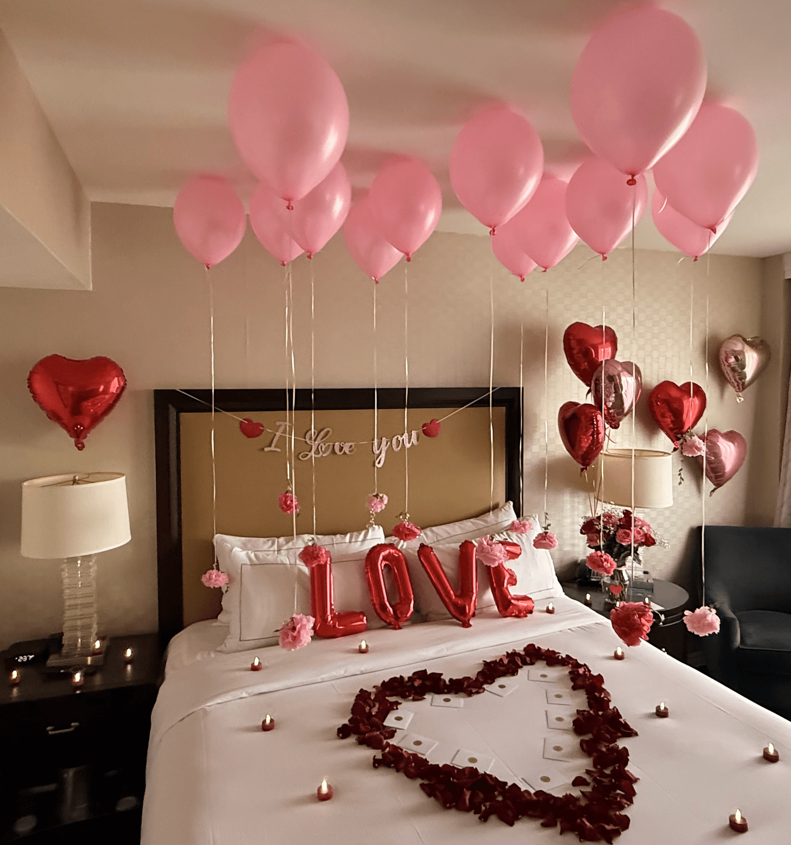Romantic suite with heart balloons and rose petals